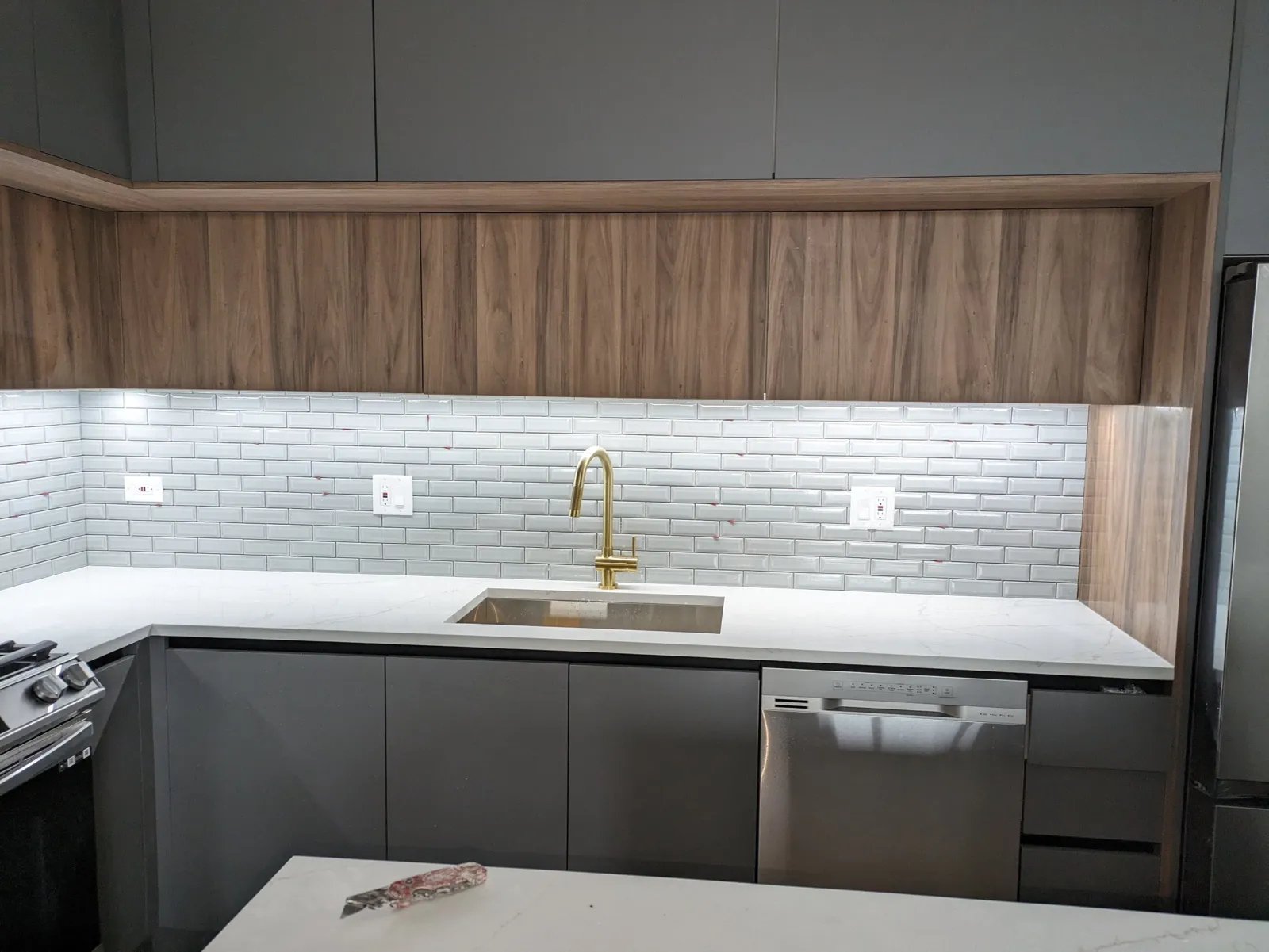 Beveled 2x6 subway tile backsplash on sink wall with brass faucet, Northbrook IL