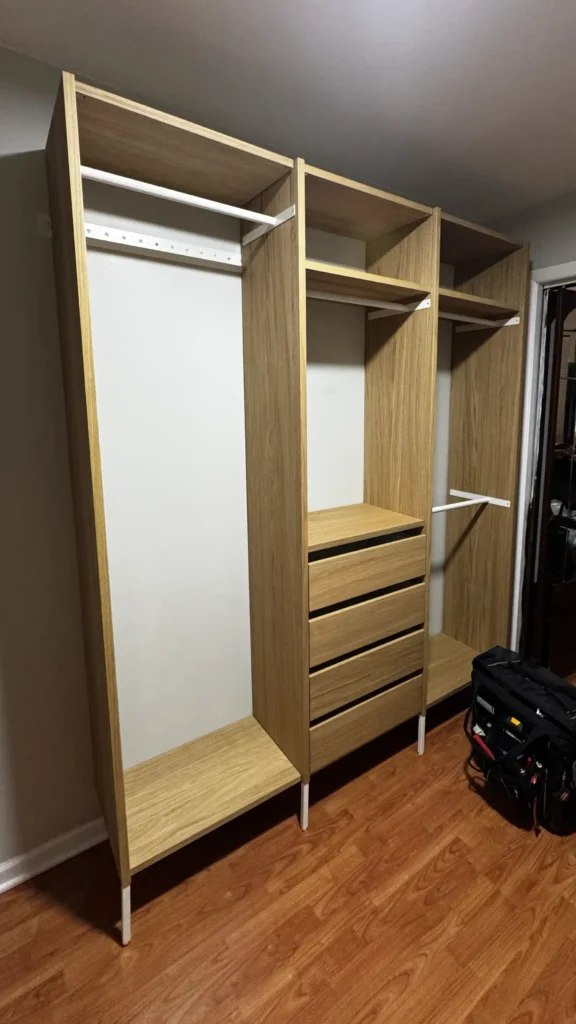 Side view of IKEA AURDAL closet organizer with wood-look panels, hanging rod and four drawers