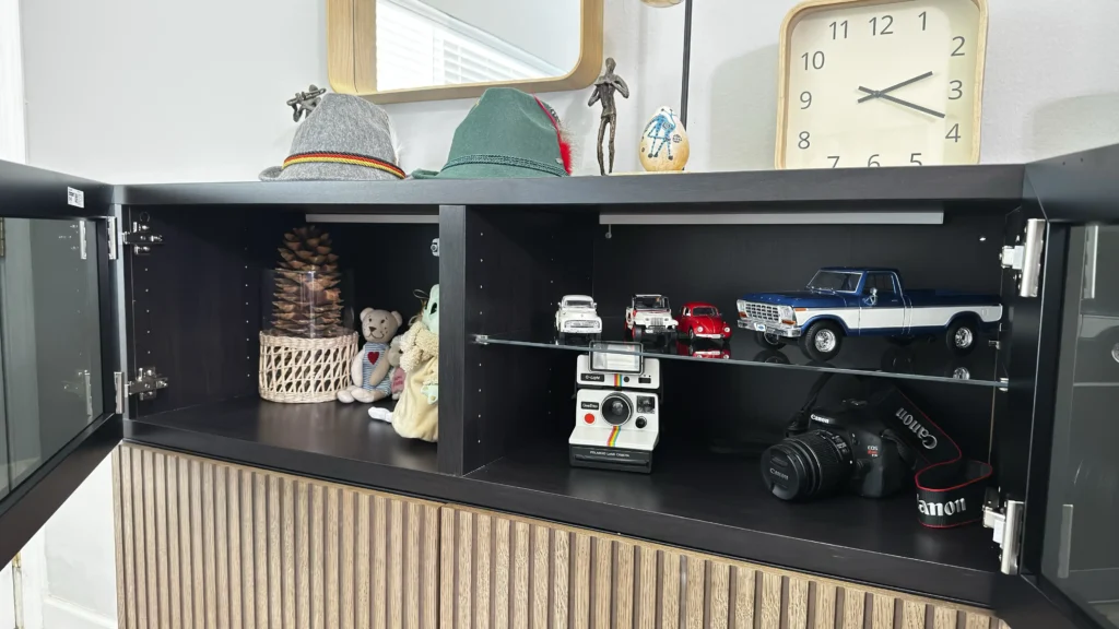 Interior of IKEA BESTÅ display cabinet with glass shelf, open doors and storage compartments
