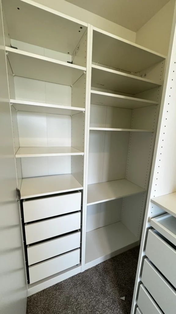 White IKEA PAX closet with adjustable shelves and four drawers installed on carpet in Buffalo Grove, IL.