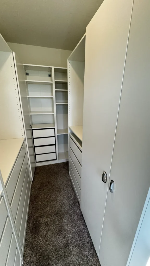 View of an IKEA PAX walk-in closet layout with white wardrobes, shelving and drawer units in Buffalo Grove, IL.