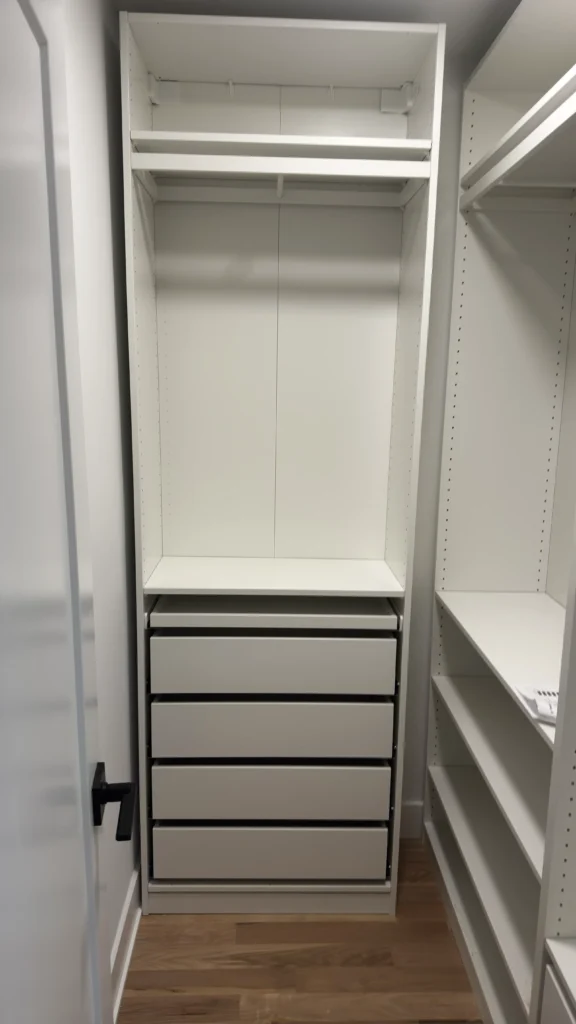 Narrow white IKEA PAX wardrobe with four drawers, shelves and a hanging rail in Lake Forest, IL.