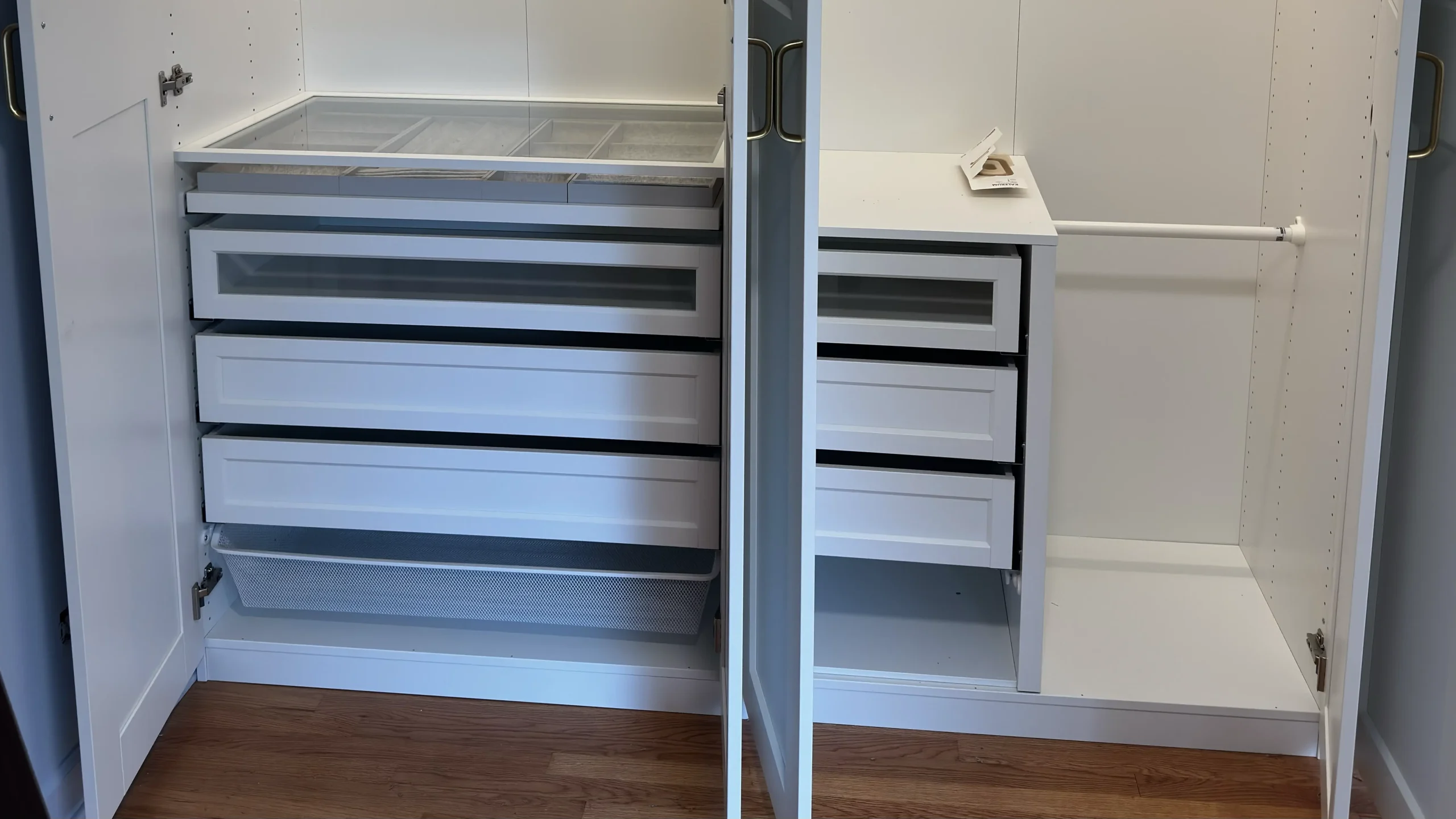 Close-up of pull-out drawers, glass-front organizers and a mesh basket inside an IKEA PAX wardrobe in Palatine, IL