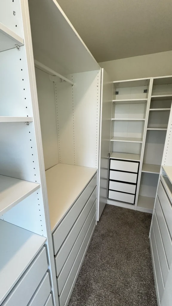 IKEA PAX walk-in closet with white storage cabinets, drawers and hanging sections installed in Buffalo Grove, IL.