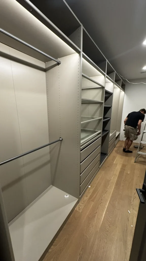 IKEA PAX walk-in closet with illuminated shelves, hanging rails and drawers in Lake Forest, IL.