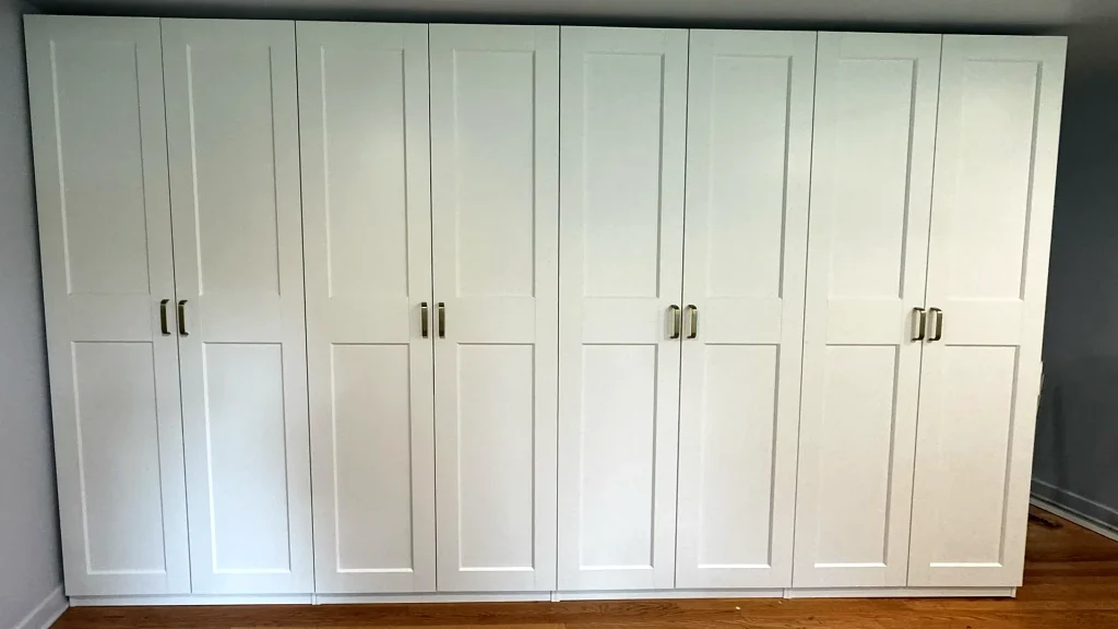 White IKEA PAX wardrobe with eight shaker-style doors and brass handles installed in Palatine, IL