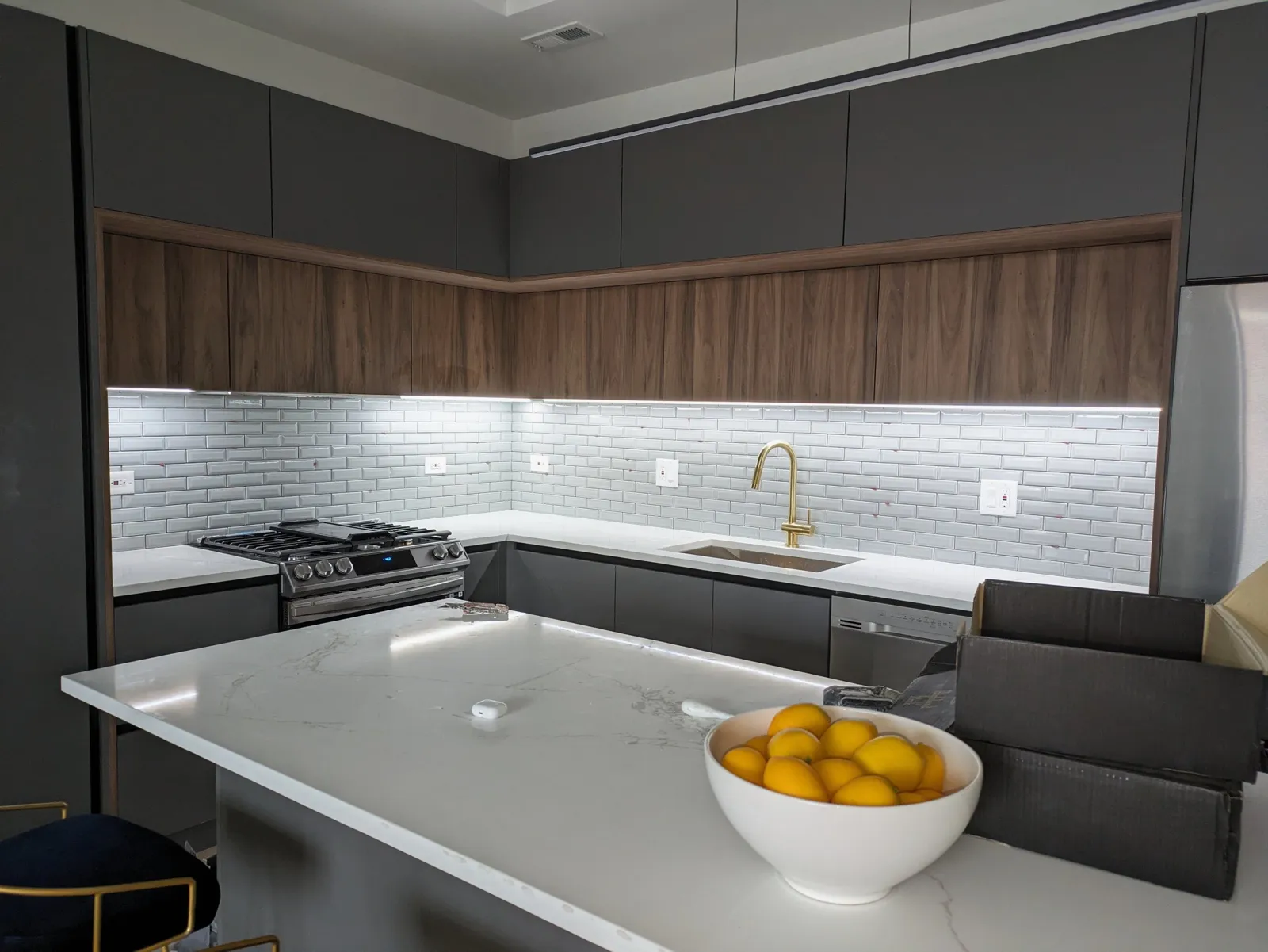 Subway tile backsplash lit by under-cabinet lighting in new construction kitchen, Northbrook IL