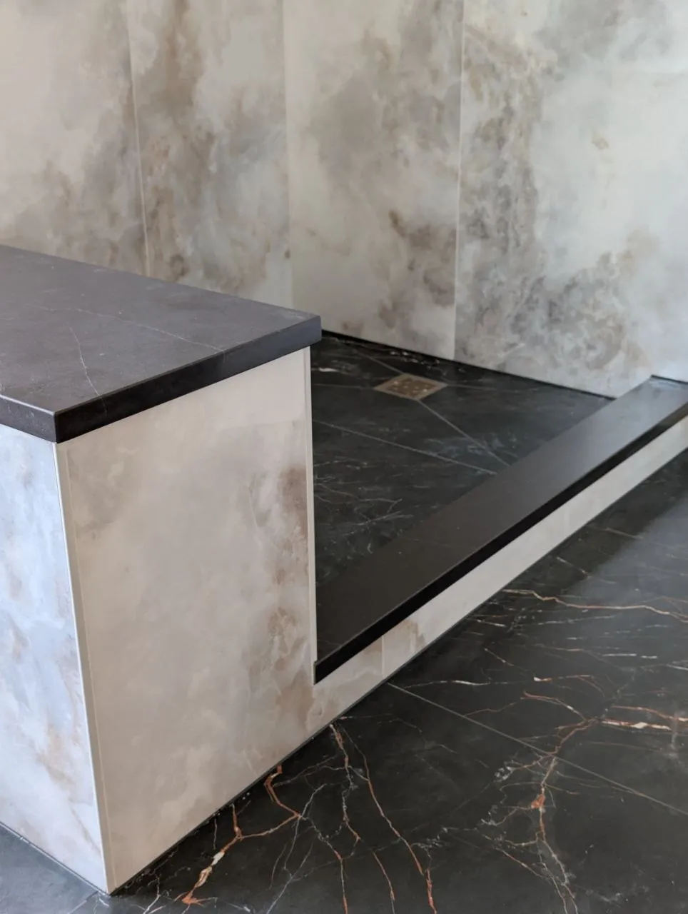 Shower pan drain and slab curb detail beside tiled bench, Naperville IL